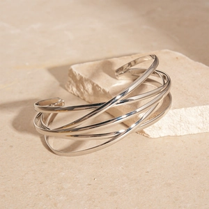 Macro shot of silver multi-layer crossover open bangle with a polished metallic finish