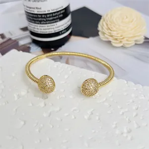 Bracciale rigido placcato oro 18K con texture rigata e sfere di zirconi su base di pietra