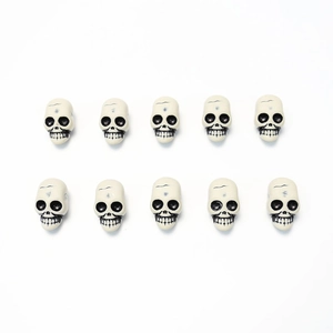 Detailed view of ten mini resin skull beads with black eye sockets for Halloween DIY