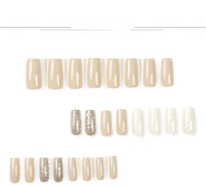 Detail view of 24 pieces of short square press-on nails in beige, gold glitter, and creamy white