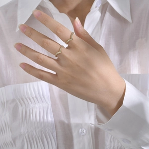 Elegant gold V-shaped zircon stackable rings for women shown on a hand with white shirt