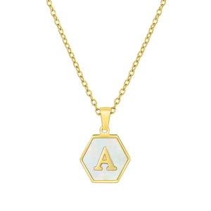 Macro detail of hexagonal gold pendant with white shell inlay and gold letter A