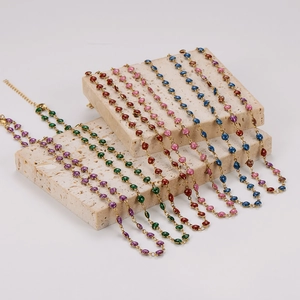 Colorful beaded heart necklace with gold chain displayed on elegant stone pedestals
