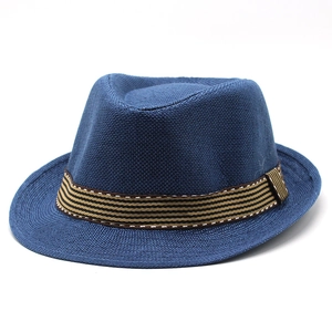 Détail d'un chapeau fedora bleu foncé en paille tressée avec ruban rayé bicolore