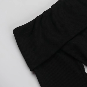 Detailed close-up of premium black ribbed knit fabric texture on an off-shoulder dress