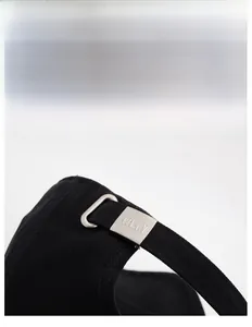 Close-up of black baseball cap back with adjustable strap and silver metal buckle