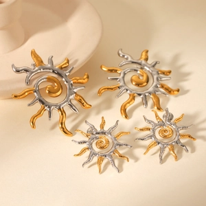 Macro view of sun-shaped stainless steel earrings with two-tone gold and silver finish