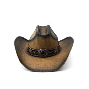 Detail of western straw cowboy hat featuring ethnic embroidery and a red gemstone