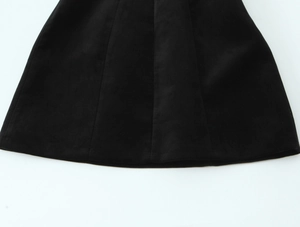 Gros plan détaillé d'une robe courte noire avec ourlet duveteux et texture en daim premium