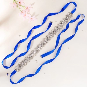 Elegant silver rhinestone wedding belt with blue satin ribbon on a white floral background