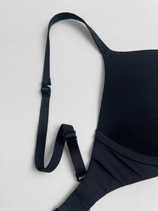 Macro detail of adjustable shoulder straps and seamless edges on a black push-up bra