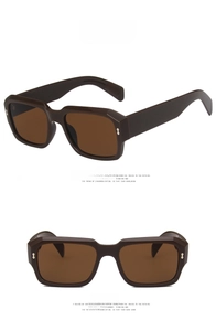 Detail view of square retro sunglasses with thick brown frames and rice nail rivets