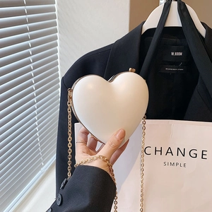 Mini white heart-shaped crossbody bag with gold edges and elegant chain strap