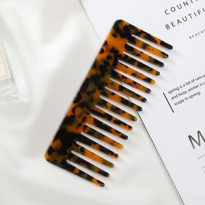 Fashionable acetate tortoiseshell wide-tooth hair comb on silk and magazine backdrop