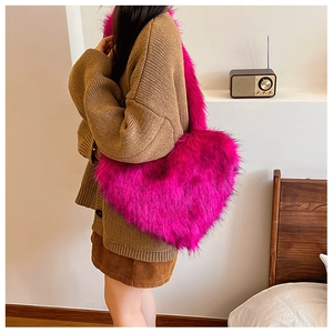 Macro detail of the heart-shaped plush faux fox fur handbag in vibrant rose red