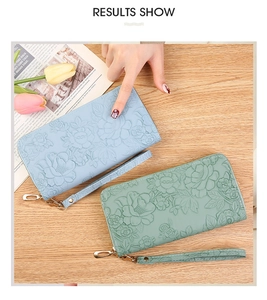 Detail of floral embossed PU leather wallet with zipper closure and wrist strap