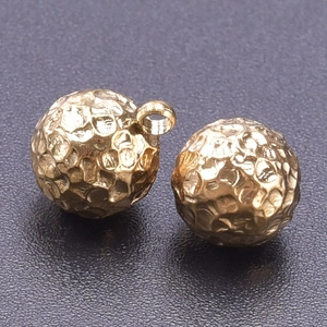 Macro detail of 18k gold plated hammered 304 stainless steel balls for DIY jewelry