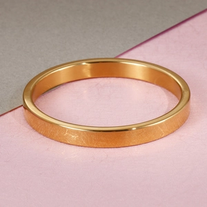 Minimalist flat golden stainless steel bangle bracelet for women on a two-tone background