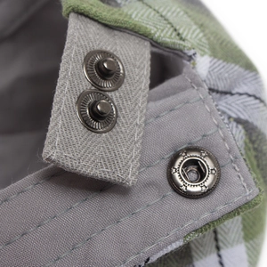Macro view of adjustable metal star buckle on vintage plaid beret cap for men and women