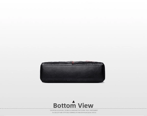 Detail view of black litchi texture leather handbag base with red stitching accent