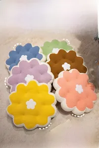 Close-up of colorful flower-shaped plush seat cushions with soft waffle texture and petal details