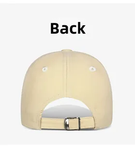 Detail view of the beige baseball cap's back with adjustable metal buckle strap