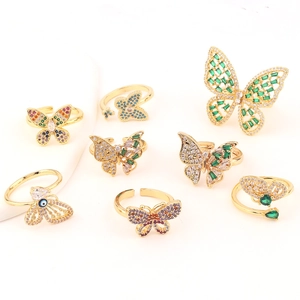 Collection of golden butterfly rings with multicolored zircon stones on white display