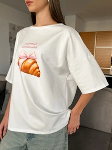Λεπτομέρεια από λευκό βαμβακερό t-shirt με τύπωμα κρουασάν και ροζ φιόγκο