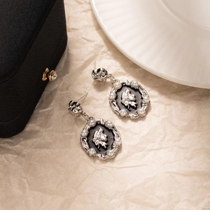 Vue macro de boucles d'oreilles relief vintage avec métal argenté et perles