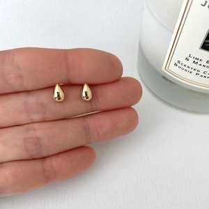 Elegant 925 sterling silver gold teardrop stud earrings shown on finger