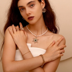 Close-up of a model wearing 14K gold plated stainless steel heart and flower jewelry set