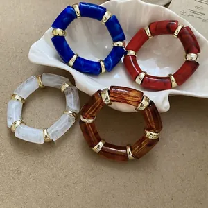 Bamboo style acetate resin bangles in blue, red, white, and amber with gold spacers
