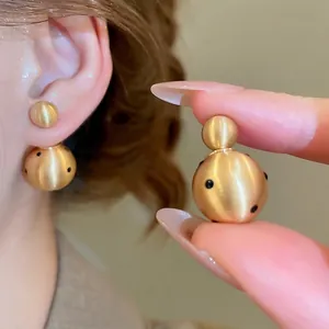 18k gold plated brushed metal stud earrings with black polka dots on double spheres