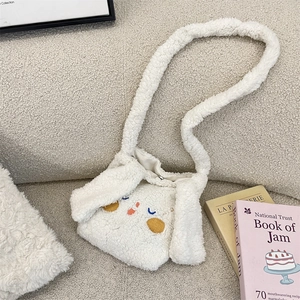 Dettaglio della borsa a tracolla in peluche a forma di coniglio bianco morbido