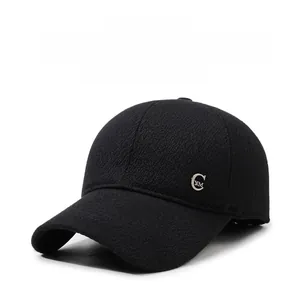 Close-up of a black winter baseball cap showing thick textured fabric and metallic logo