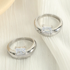 Minimalist irregular silver rings with square zircon stones on white textured fabric