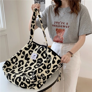 Detail shot of beige leopard print canvas tote bag featuring a branded white woven label