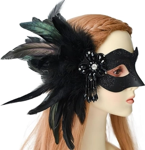 Détail d'un masque de bal à plumes noires avec base pailletée et accent de fleur en gemme