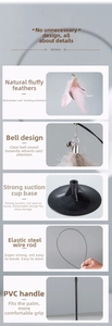 Detail view of cat teaser wand showing pink feather, bell, steel wire, and suction cup base