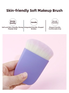Detailed view of soft synthetic makeup brush with purple handle and gradient bristles