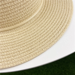 Close-up of the woven texture and straw fibers on a wide-brim beige summer sun hat