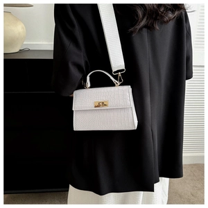 Rear view of model wearing white crocodile pattern crossbody bag with gold twist lock