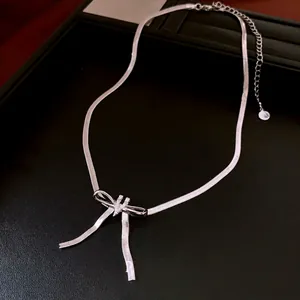 Elegant silver snake chain necklace with sparkling zircon bow pendant on black background