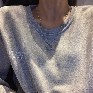 Silver chain necklace featuring a minimalist ring pendant on a streetwear style sweater