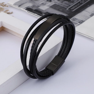 Close-up of men's multi-layer black braided leather bracelet with matte metal magnetic clasp