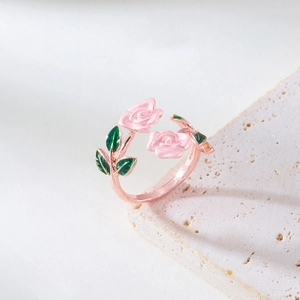 Detail of rose-shaped adjustable ring with pink enamel petals and green leaves