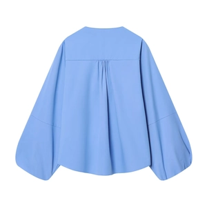 Dos d'une chemise en popeline bleu clair avec manches ballons et pli plat au milieu