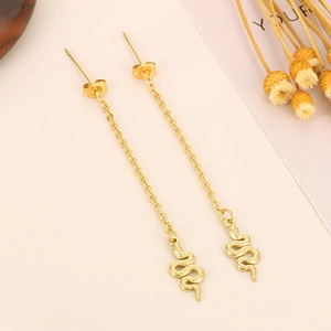 Close-up of vintage gold snake chain earrings with textured relief on light background