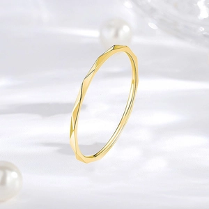 Macro view of a 1mm minimalist geometric gold ring with elegant diamond-cut facets