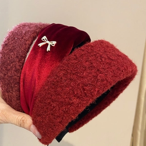 Close-up of red plush headband with velvet bow and golden butterfly metal ornament